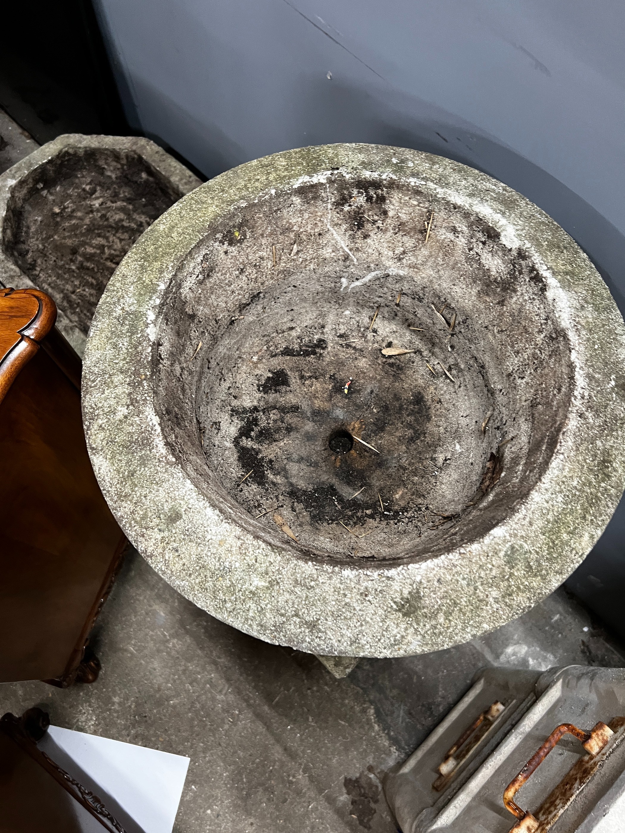 A circular reconstituted stone garden planter on square plinth, diameter 40cm, height 84cm together with an octagonal shallow stone planter, width 62cm, height 33cm